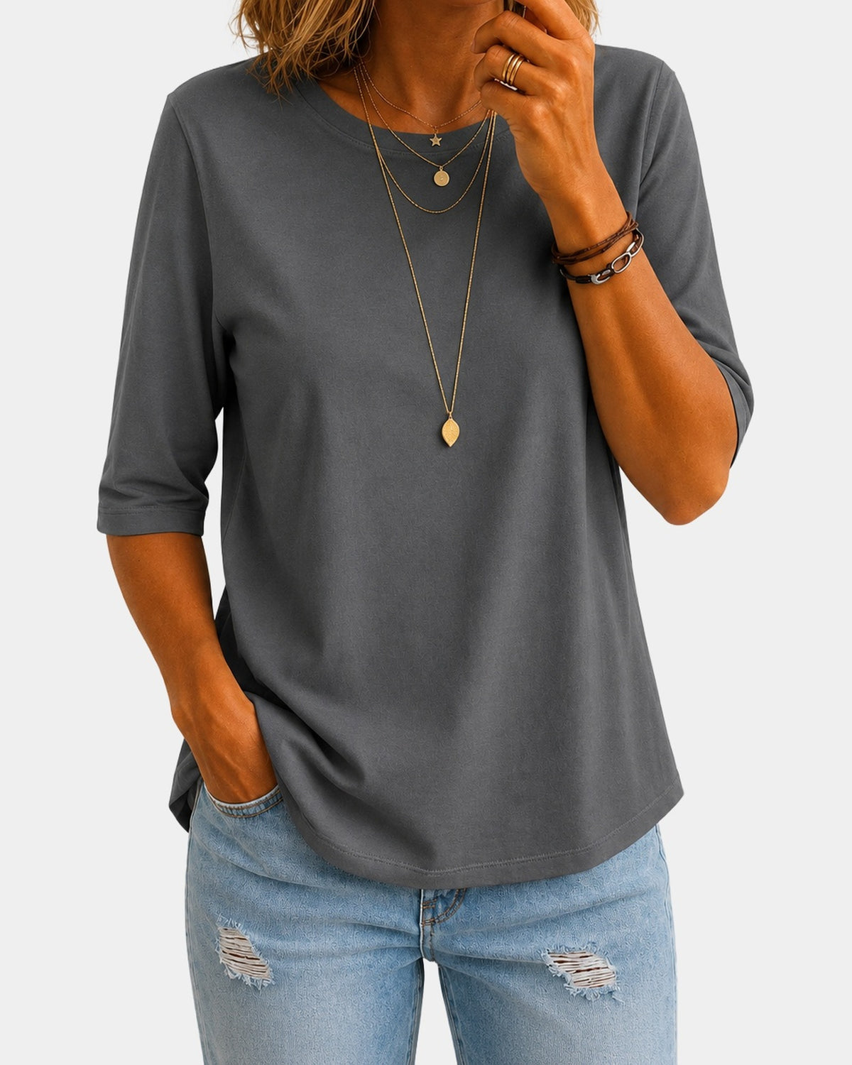 Sylvie relaxed half-sleeve tee in grey, worn with jeans, on a light grey studio background